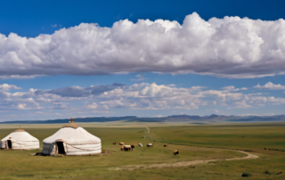 Paysage de steppe en Mongolie, avec des yourtes et un ciel menaçant à l’horizon